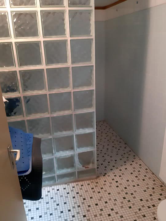 Eine Dusche im Keller mit geprungenen Glasbausteinen auf Grund von Setzungsrissen im Gebäude. 
